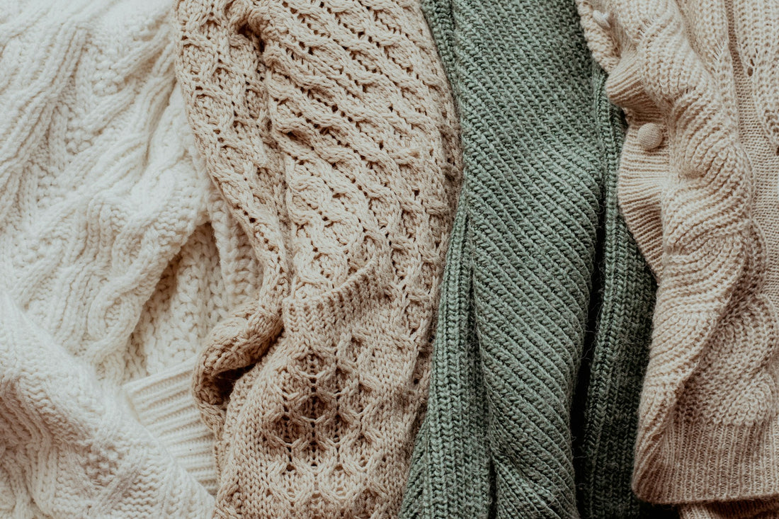 Pile of knit sweaters showing fabric texture and pilling